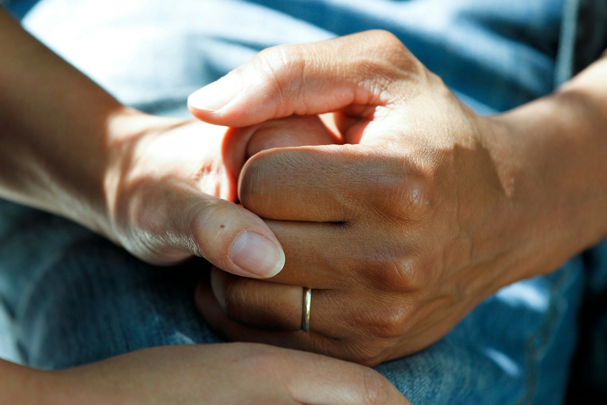 Close-up of hands offering reassurance and support